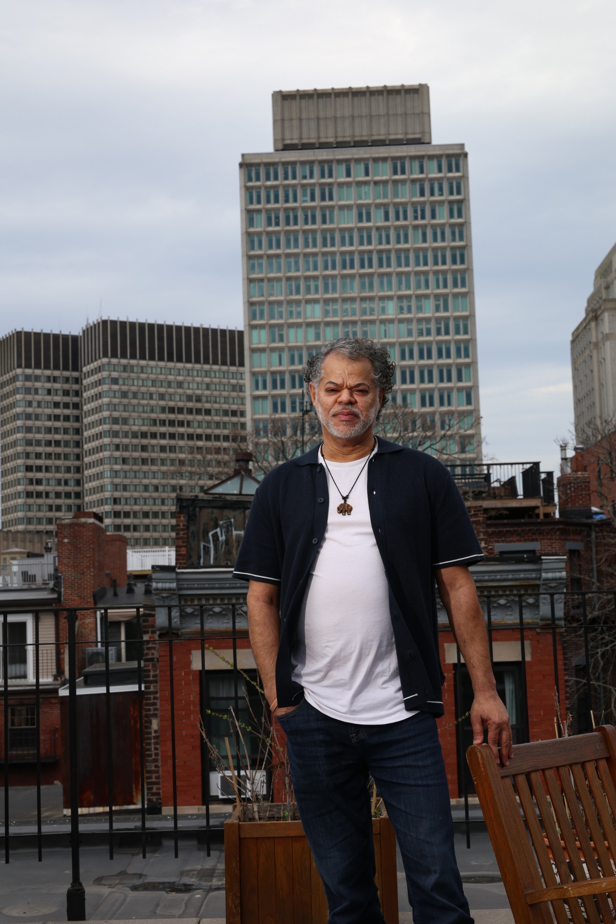 Eduardo Pereira poses for a photo on the Joy Street Residence roof deck overlooking Boston's Beacon Hill neighborhood.